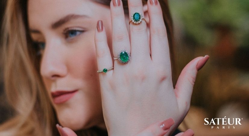 Esmeraldas na mão do anel de noivado
